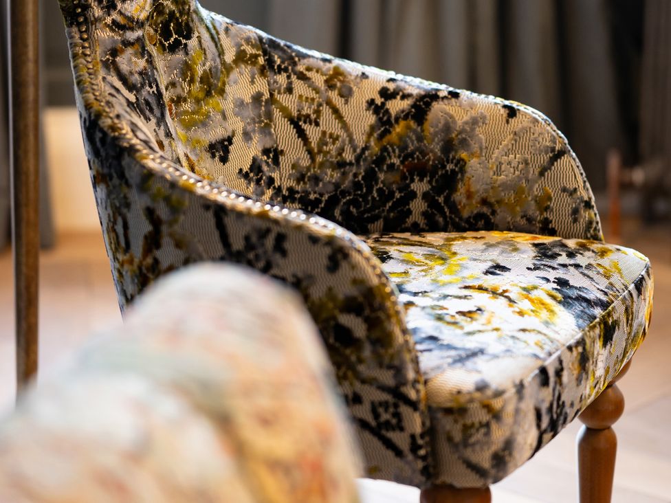 An armchair with fabric upholstery in a living room at Wren Place Hall, Worsbrough