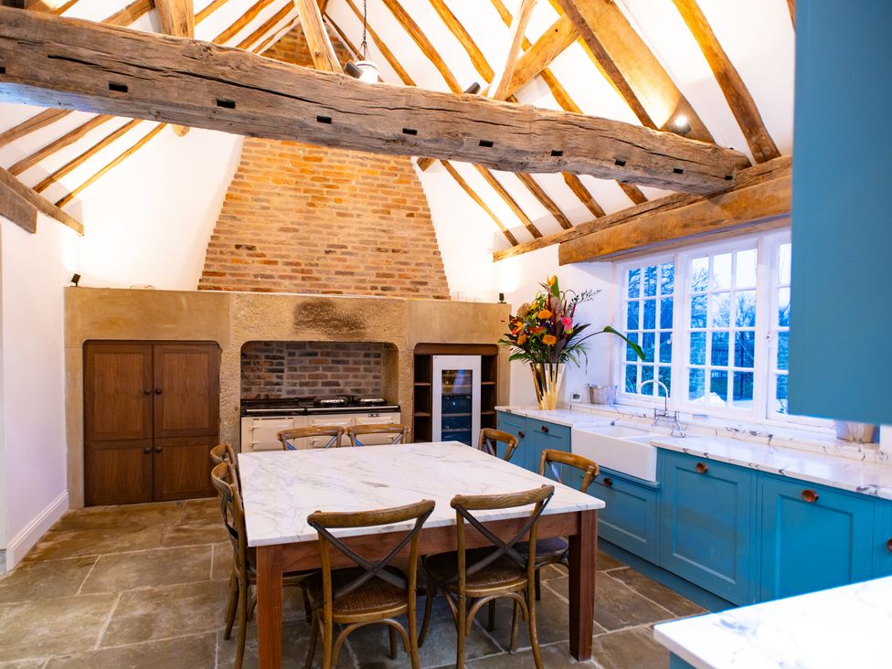A kitchen with wooden beams and a stone fireplace at Wren Place Hall in Worsbrough