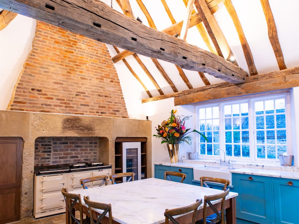 A kitchen with a wooden table and chairs at Wren Place Hall in Worsbrough