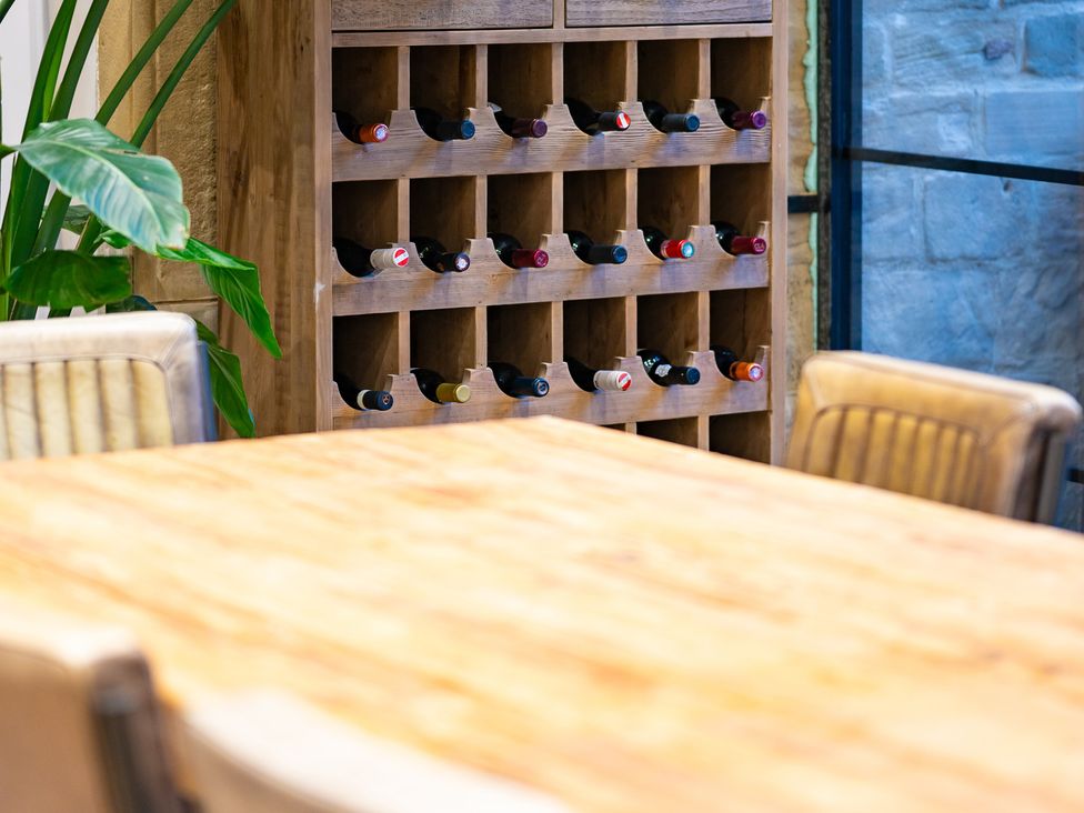 A dining room with a wine rack and table at Wren Place Hall in Worsbrough