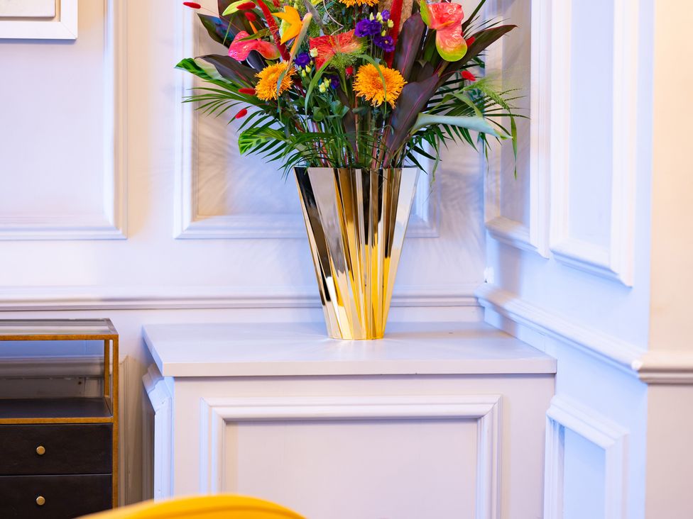 A vase with flowers on a side table at Wren Place Hall in Worsbrough