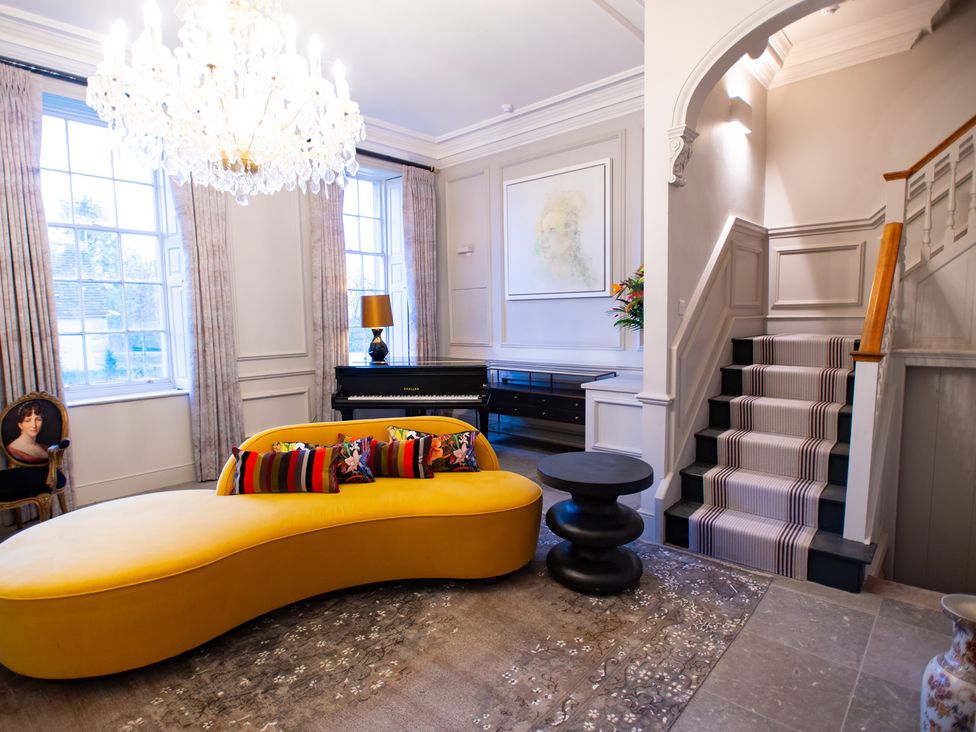 A living room with a sofa and piano at Wren Place Hall in Worsbrough