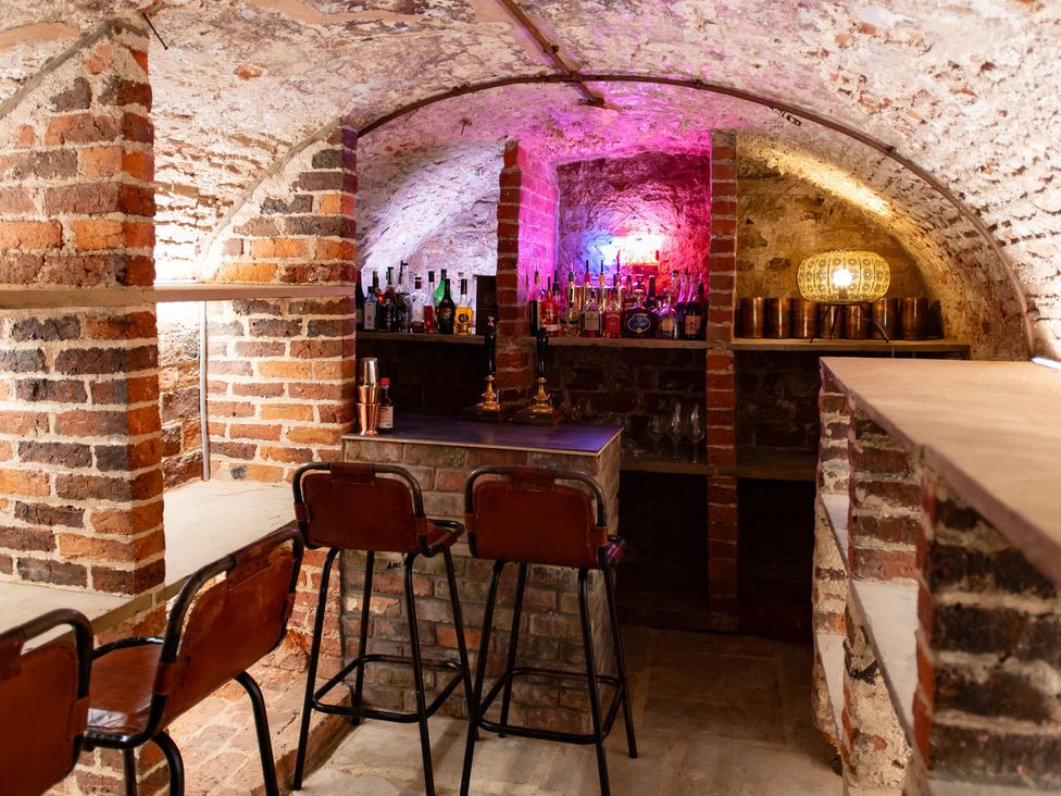 A basement bar with shelves of bottles at Wren Place Hall in Worsbrough