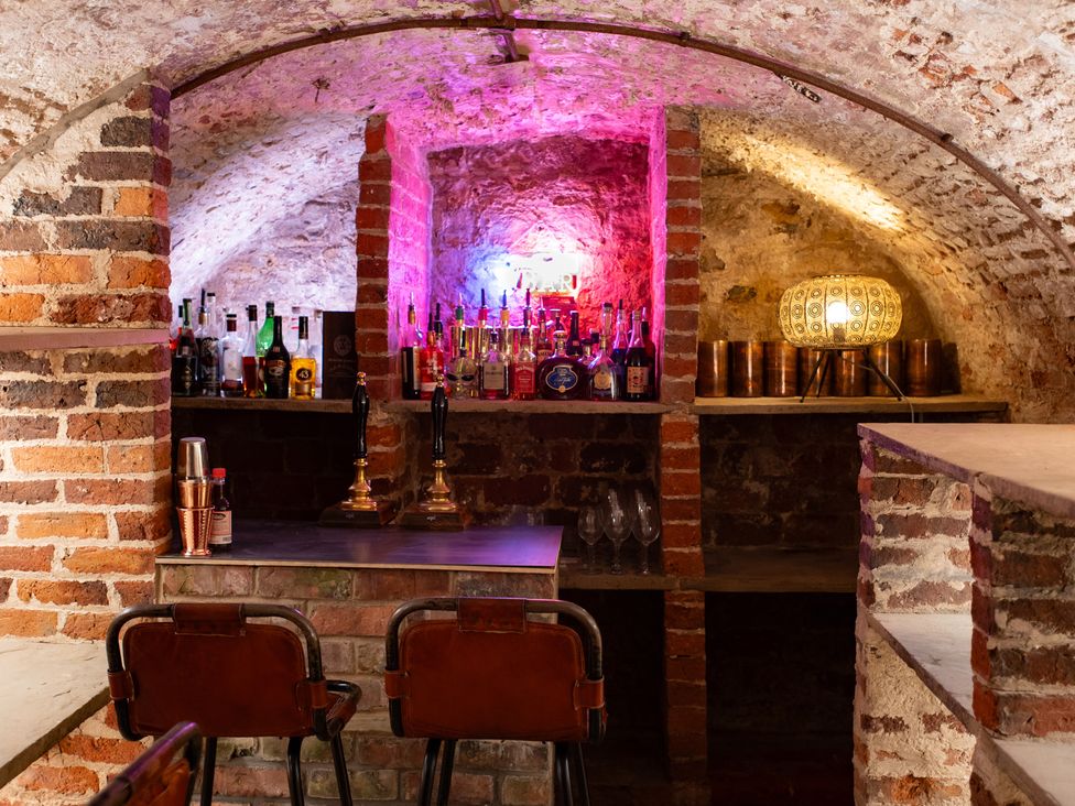 A bar area with bottles and glasses at Wren Place Hall Worsbrough