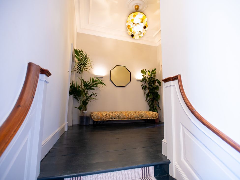 A hallway with stairs and a bench at Wren Place Hall in Worsbrough