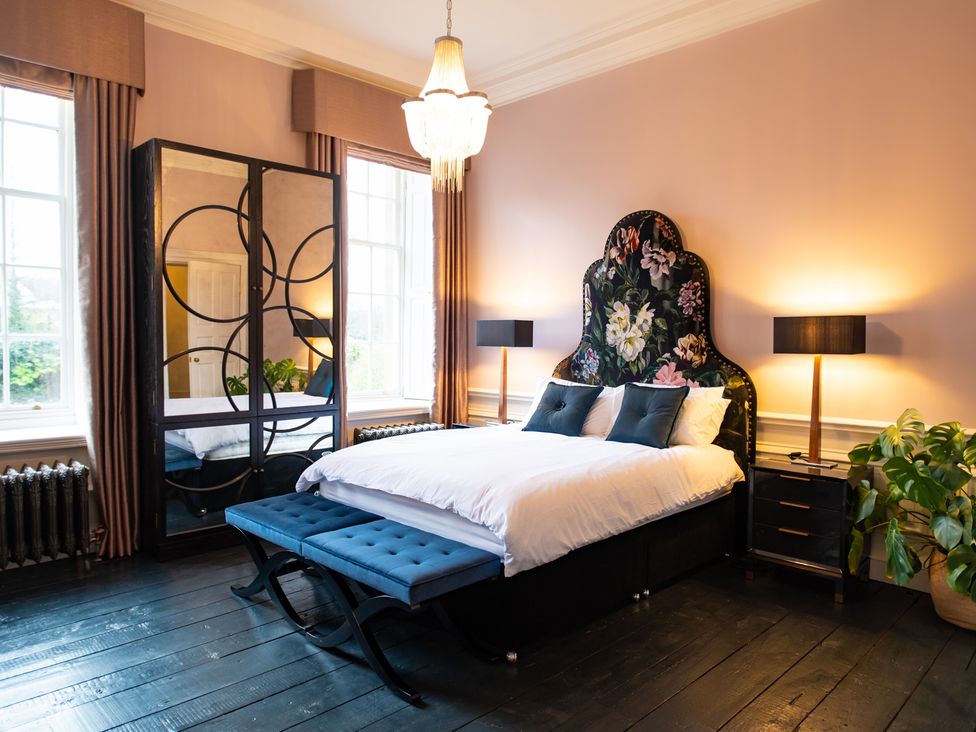 A bedroom with a bed and a mirror at Wren Place Hall in Worsbrough