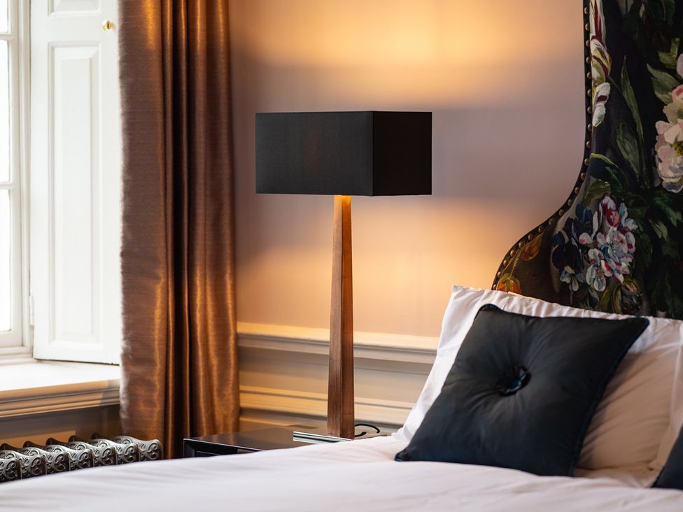 A bedroom with a lamp and bed at Wren Place Hall in Worsbrough