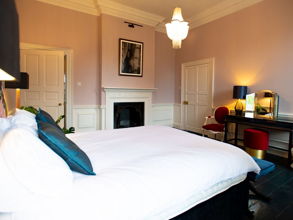 A bedroom with a bed and a fireplace at Wren Place Hall in Worsbrough