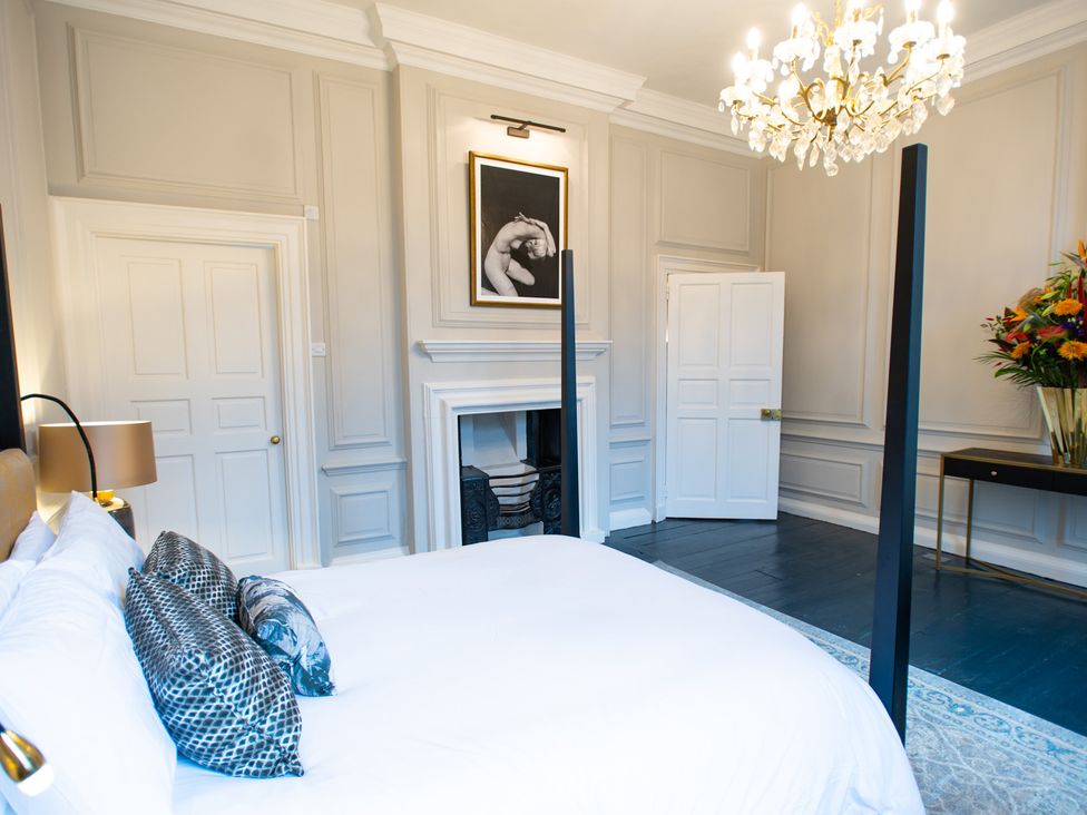 A bedroom with a bed and fireplace at Wren Place Hall in Worsbrough