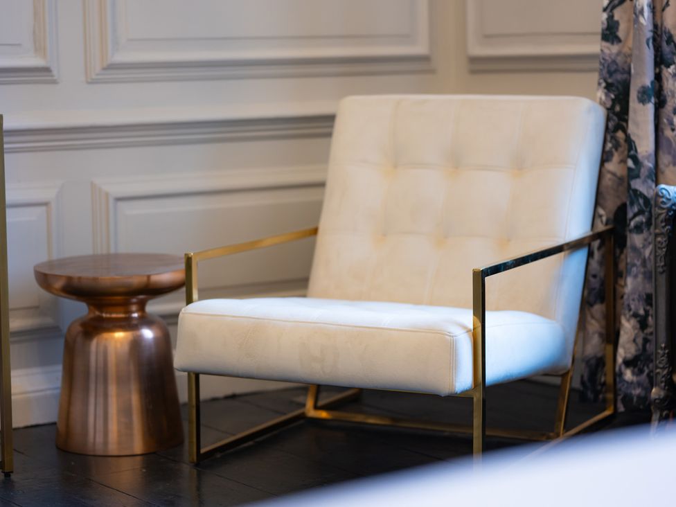 A living room with a chair and side table at Wren Place Hall in Worsbrough