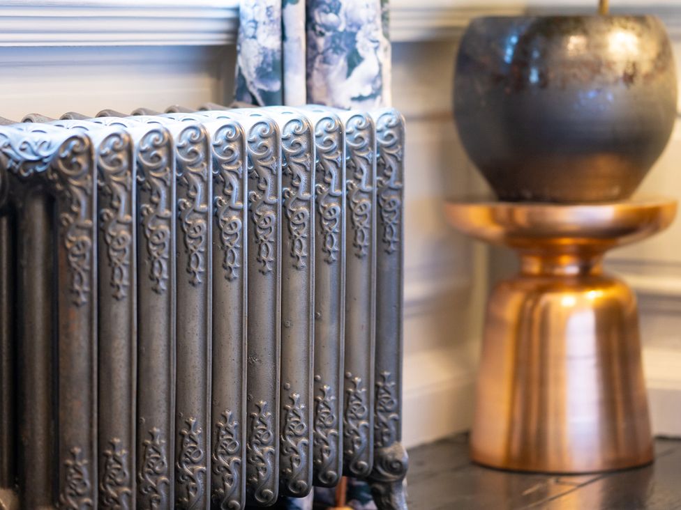 A radiator and a decorative pot on a side table at Wren Place Hall in Worsbrough