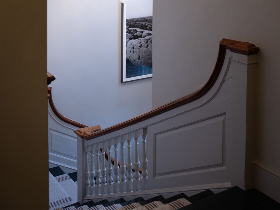A staircase with a handrail and picture on the wall at Wren Place Hall in Worsbrough