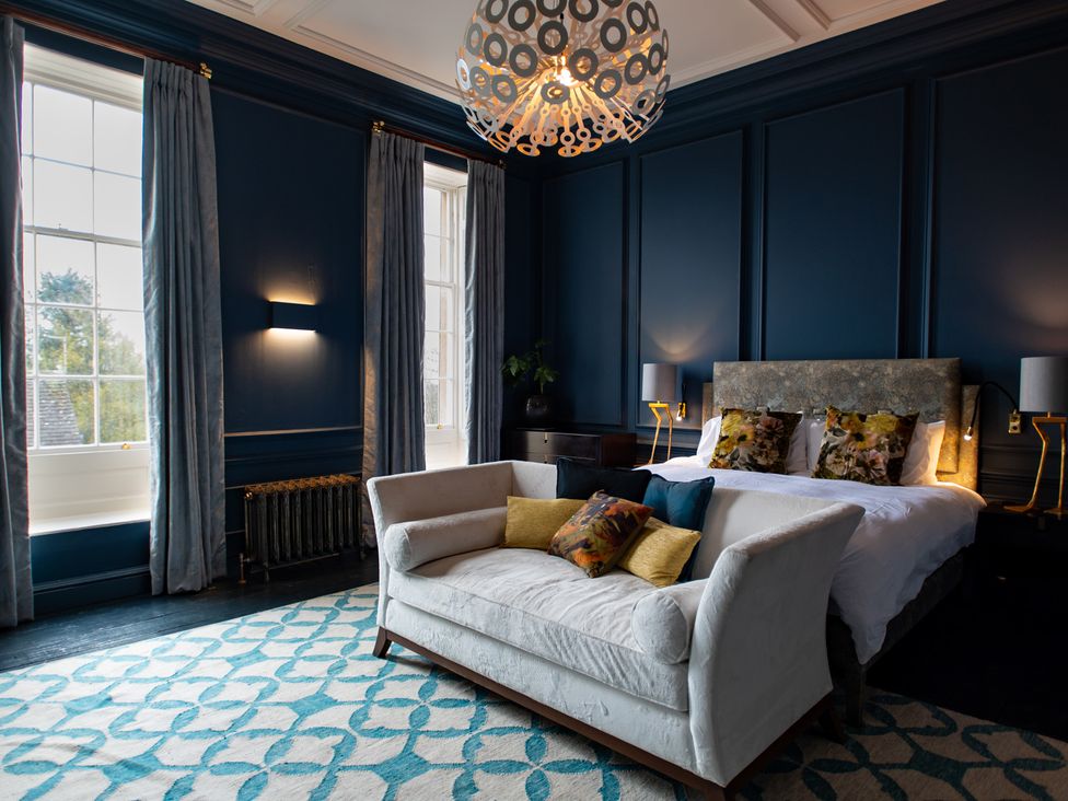 A bedroom with a bed and a sofa at Wren Place Hall Worsbrough