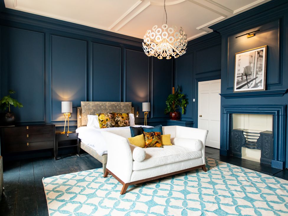 A bedroom with a bed and sofa at Wren Place Hall in Worsbrough