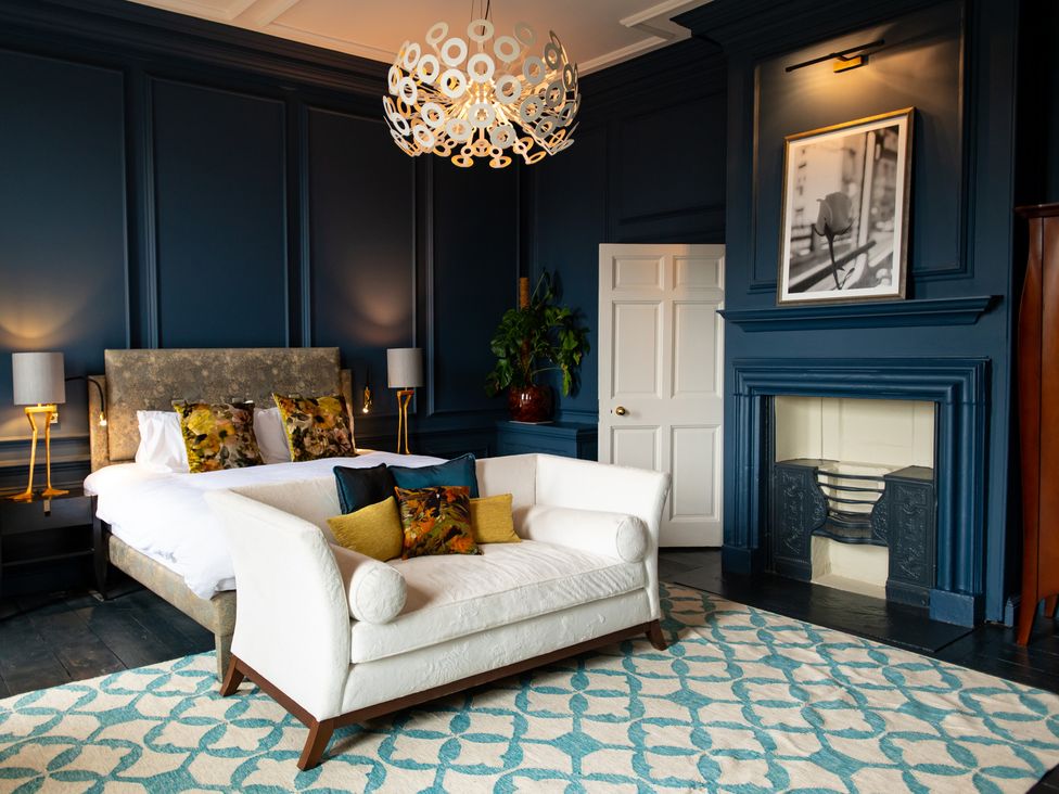 A bedroom with a bed and sofa at Wren Place Hall in Worsbrough