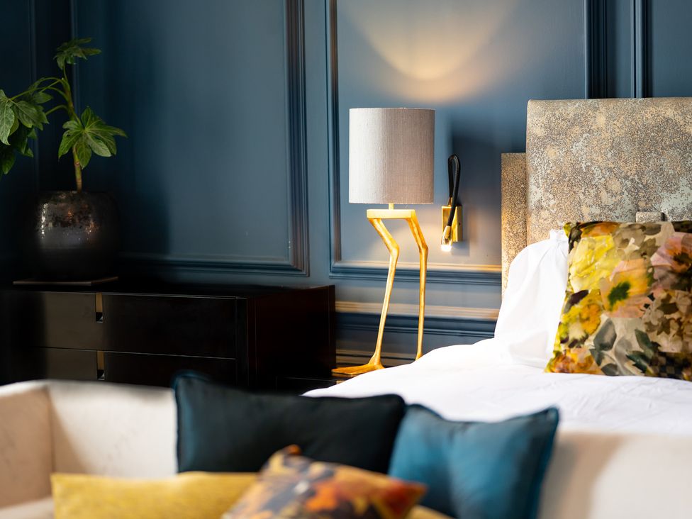 A bedroom with a bed and decorative cushions at Wren Place Hall Worsbrough