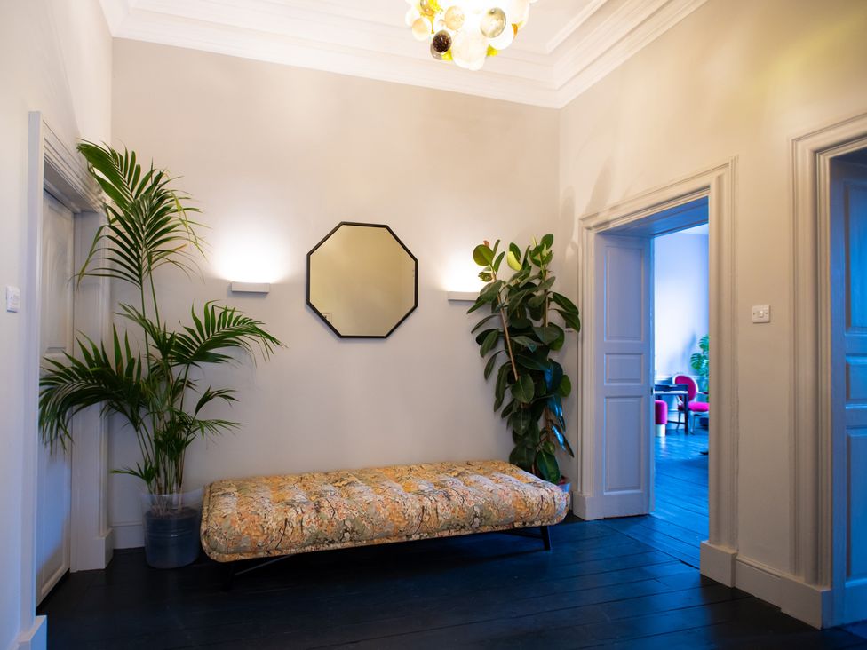 A hallway with a sofa and a plant at Wren Place Hall in Worsbrough