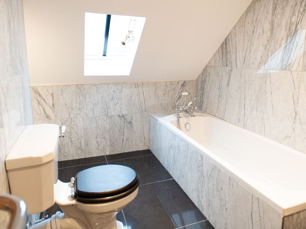 A bathroom with a bathtub and toilet at Wren Place Hall in Worsbrough