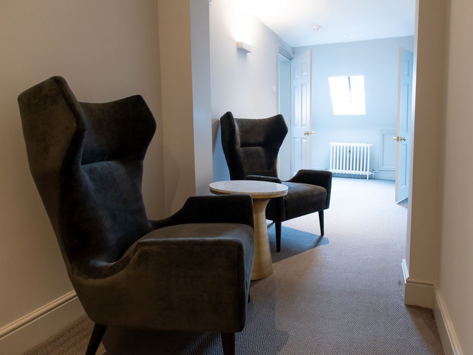 A hallway with two chairs and a small table at Wren Place Hall Worsbrough