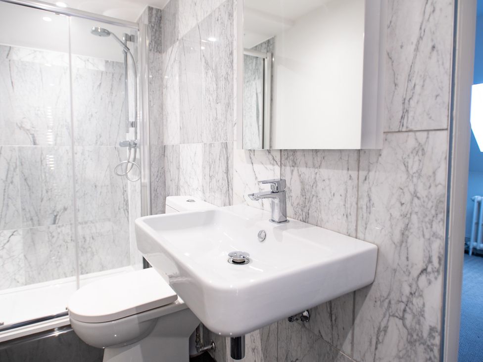 A bathroom with a sink, shower, and toilet at Wren Place Hall in Worsbrough