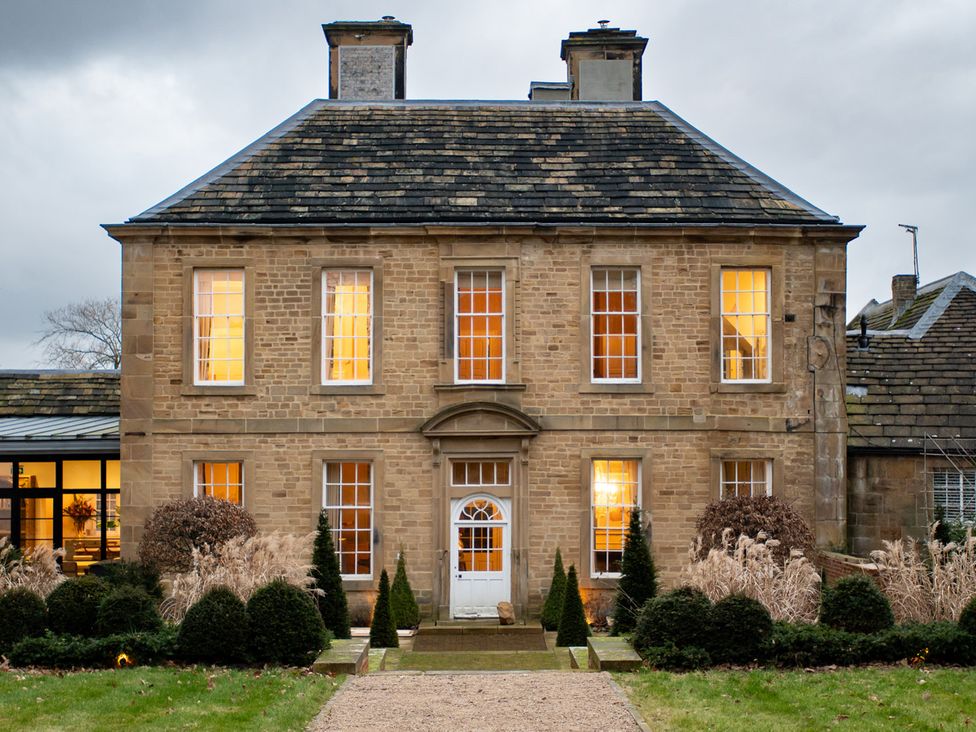 A house with lights on in the windows at Wren Place Hall in Worsbrough