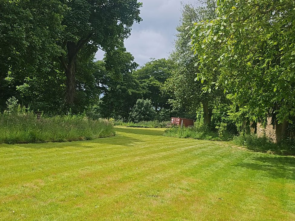 A garden with grass and trees at Wren Place Hall in Worsbrough