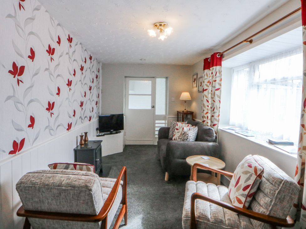 A living room with a sofa and television at Ground Floor Apartment, Tremadog