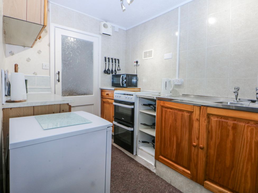 A kitchen with cabinets and appliances at Ground Floor Apartment Tremadog