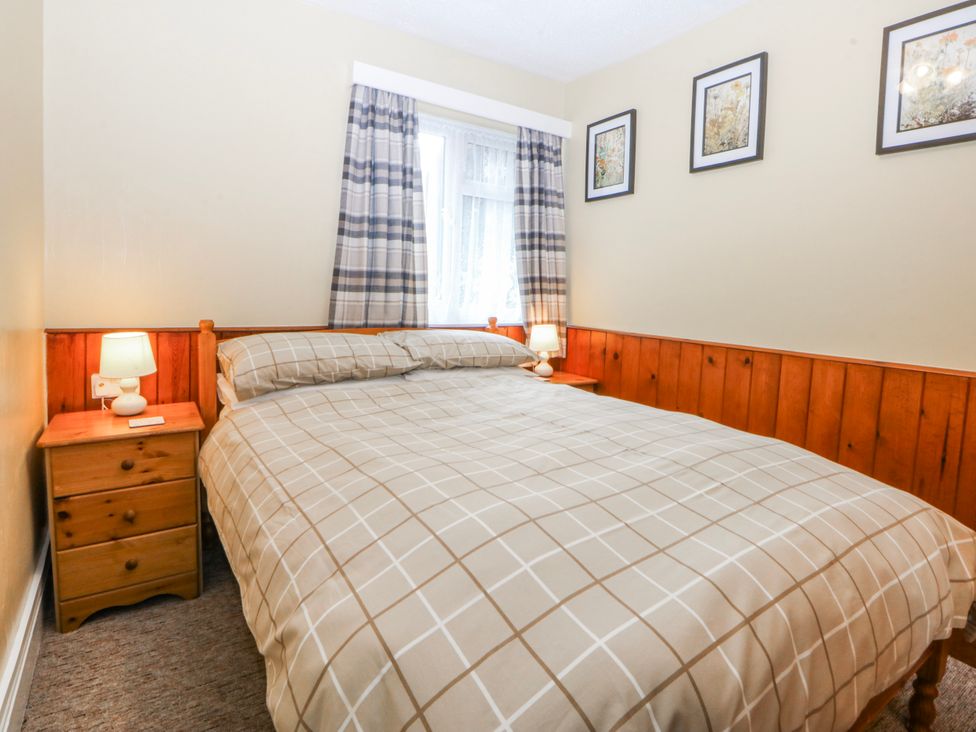 A bedroom with a bed and nightstand at Ground Floor Apartment in Tremadog