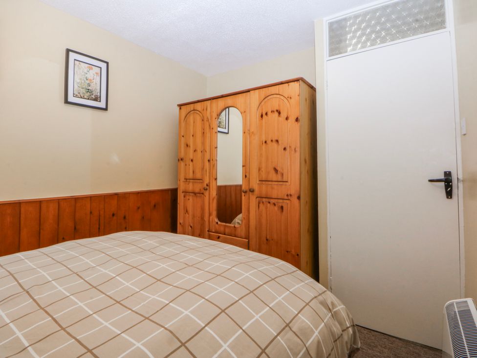 A bedroom with a bed and wardrobe at Ground Floor Apartment in Tremadog