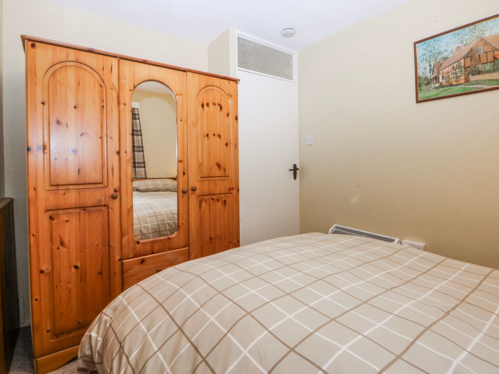 A bedroom with wardrobe and bed at Ground Floor Apartment in Tremadog