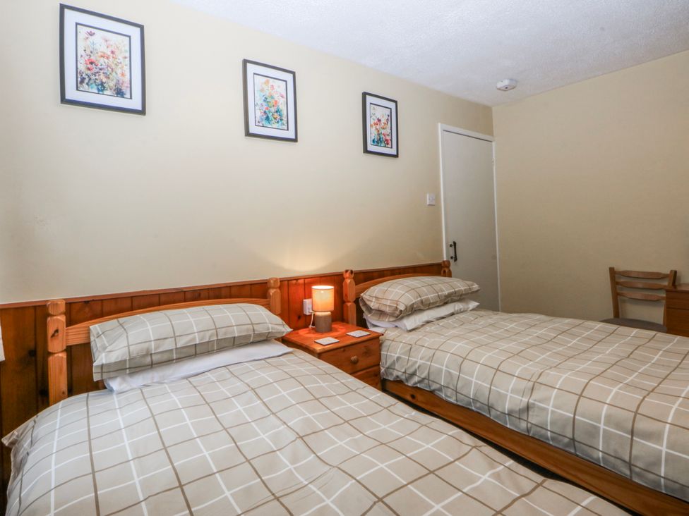 A bedroom with two beds and wall art at Ground Floor Apartment in Tremadog