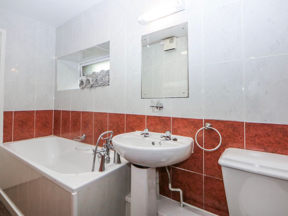 A bathroom with a bathtub sink and toilet at Ground Floor Apartment Tremadog
