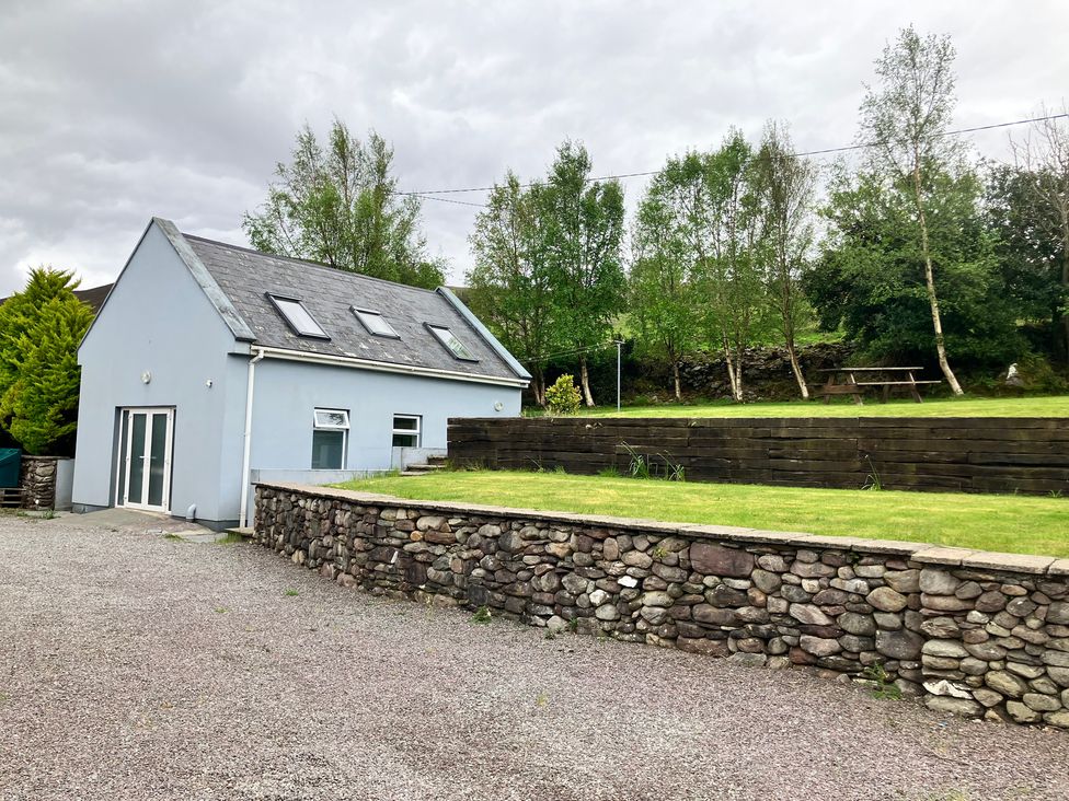 A house with a stone wall and grassy area at Silver Birch House Beaufort Killarney County Kerry
