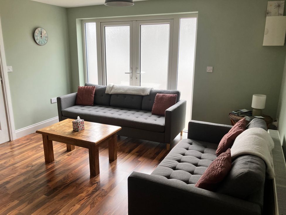 A living room with two sofas and a wooden table at Silver Birch House Beaufort Killarney County Kerry