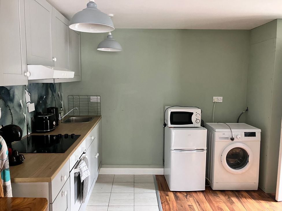 A kitchen with a sink, stove, and washing machine at Silver Birch House Beaufort Killarney, County Kerry
