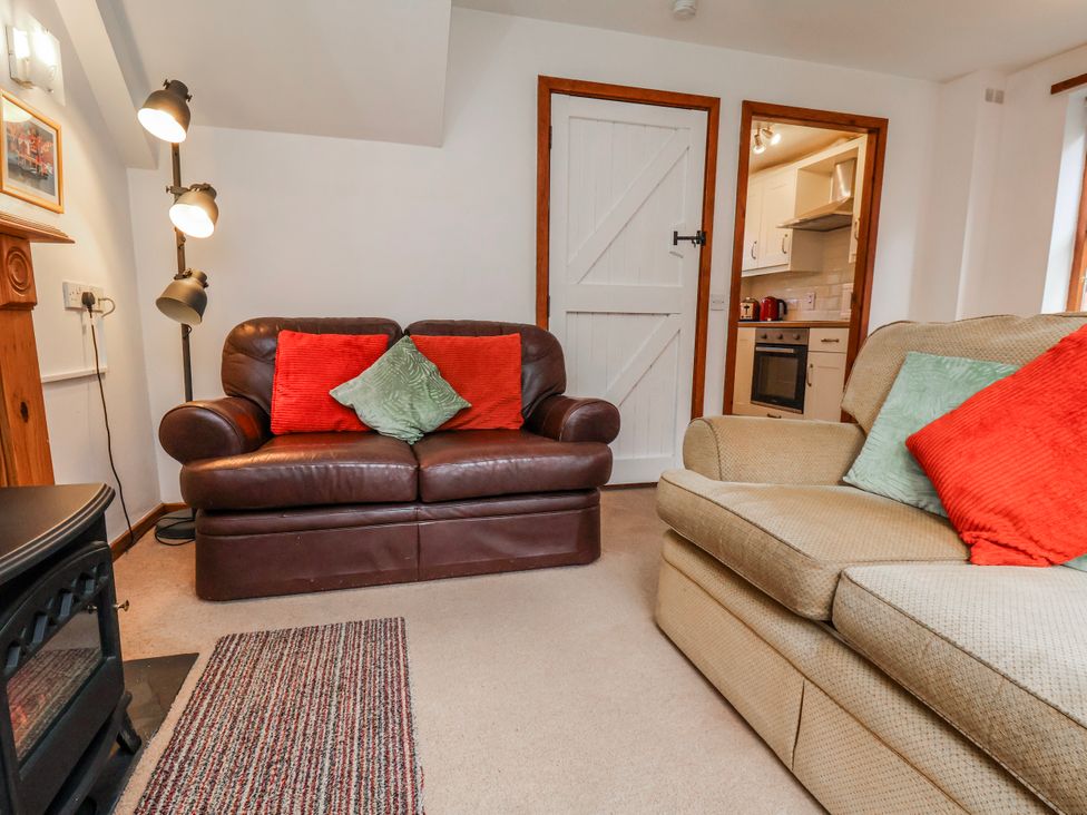 A living room with two sofas and a door leading to the kitchen at Waterside Cottage in Whitby
