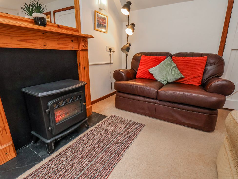 A living room with a sofa and fireplace at Waterside Cottage in Whitby