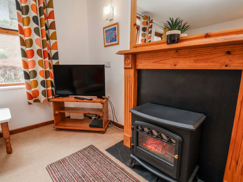 A living room with a television and fireplace at Waterside Cottage in Whitby