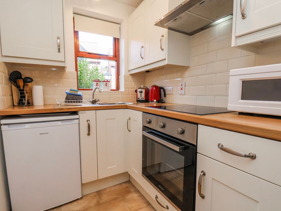 A kitchen with appliances and cabinets at Waterside Cottage in Whitby