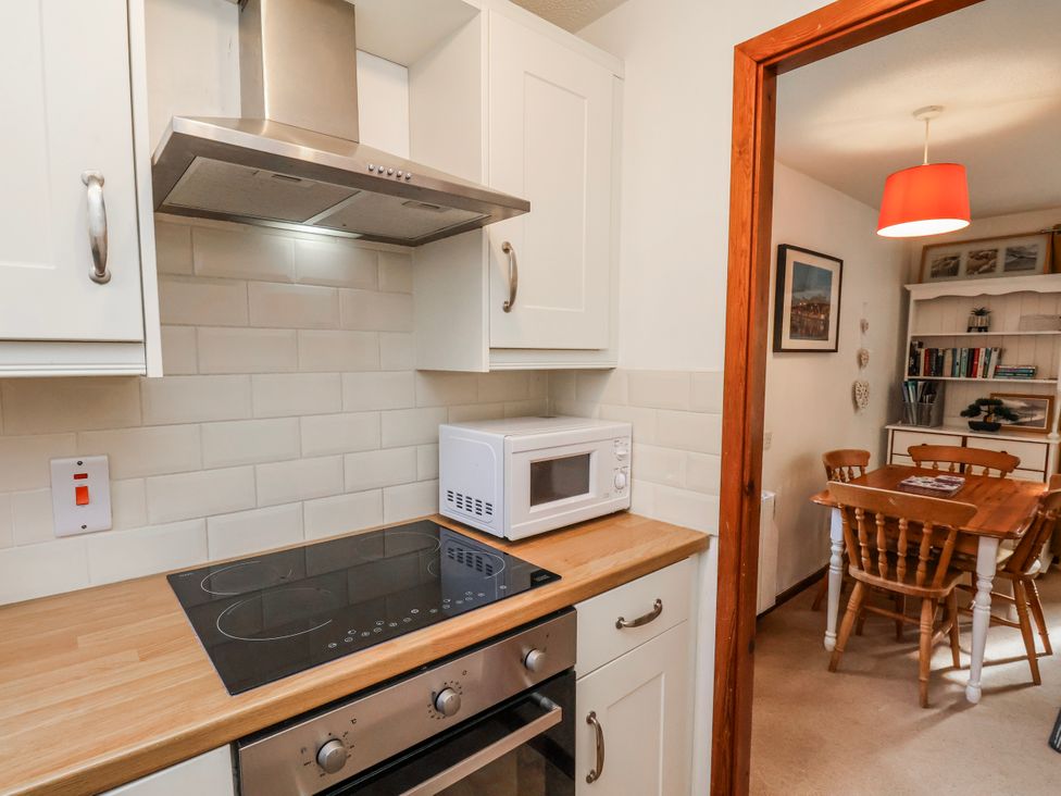 A kitchen with a cooker and microwave at Waterside Cottage in Whitby