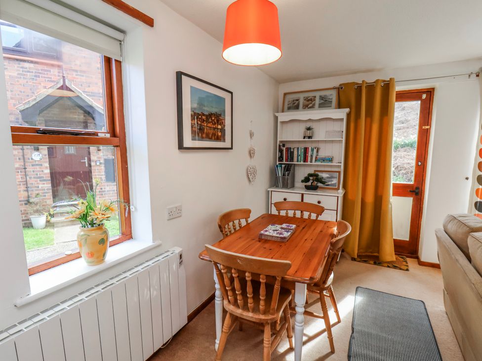 A dining room with a table and chairs at Waterside Cottage in Whitby