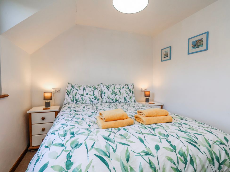 A bedroom with a bed and towels at Waterside Cottage in Whitby