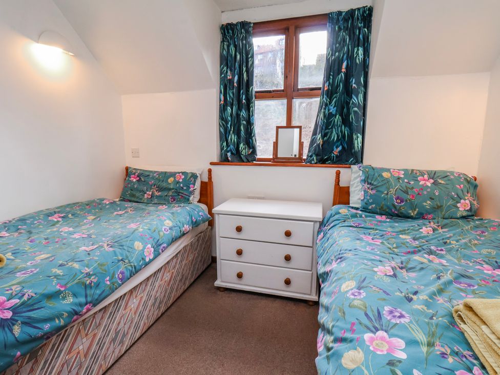 A bedroom with two beds and a dresser at Waterside Cottage Whitby