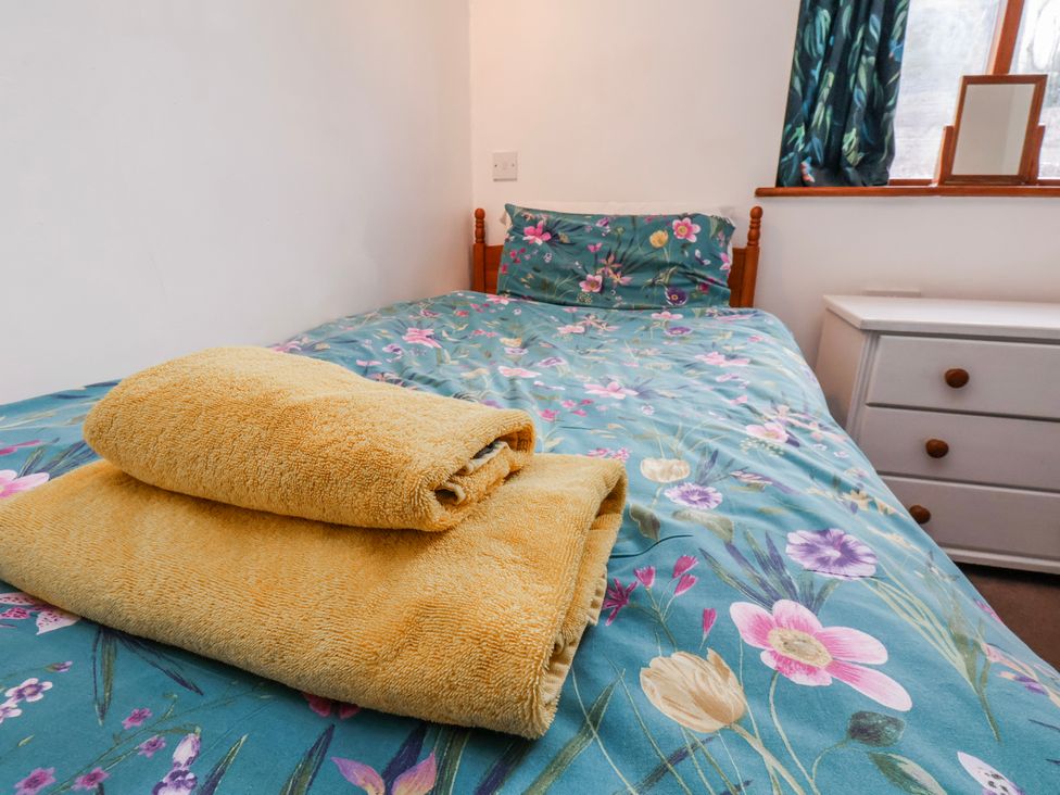 A bedroom with a bed and towels at Waterside Cottage in Whitby
