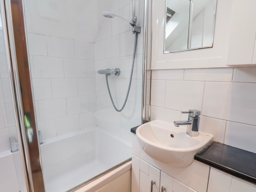 A bathroom with a bathtub, shower, and sink at Waterside Cottage in Whitby