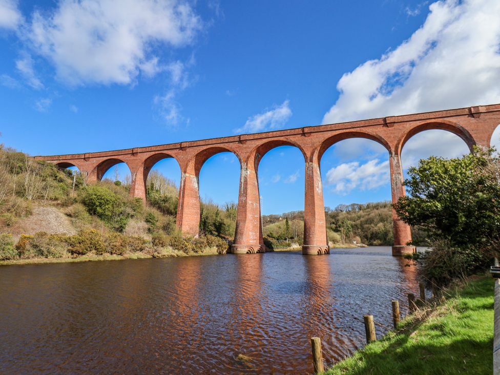 A bridge over a river with trees in the background at Waterside Cottage in Whitby