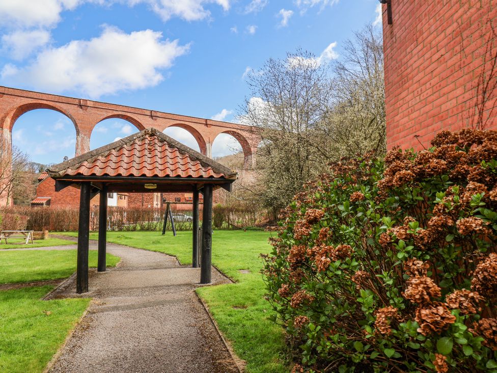 A pathway with a pavilion and bushes at Waterside Cottage in Whitby
