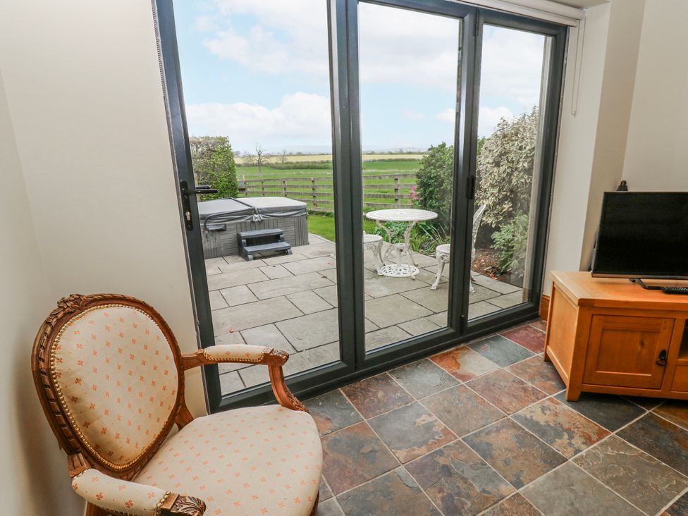 A living room with sliding doors and a view of a patio at Lovesome Cottage in Northallerton