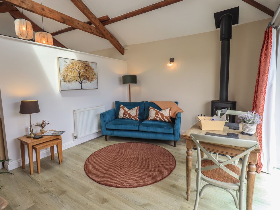 A living room with a blue sofa and wooden table at Acorn in Bowness-on-Windermere